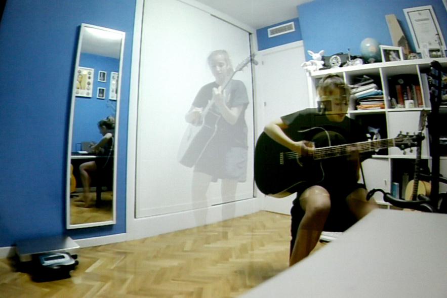 Entrega de 100 Becas FUNDAL 2017 - Imagen como de video de una persona tocando la guitarra en su habitación.
