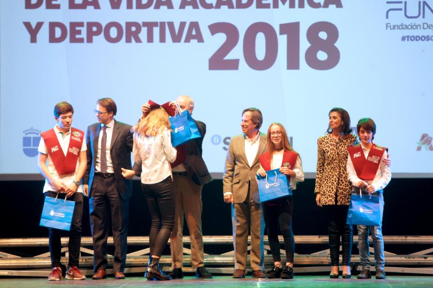 Entrega Becas FUNDAL 2018 - Imagen en el escenario de las autoridades presentes en el acto, entre ellas el alcalde García de Vinuesa y varios alumnos en el momento de recibir su beca.