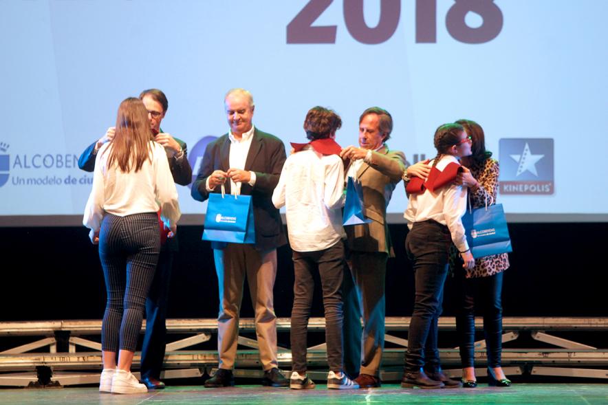 Entrega Becas FUNDAL 2018 - Imagen en el escenario de las autoridades presentes en el acto, entre ellas el alcalde García de Vinuesa y varios alumnos en el momento de recibir sus becas.