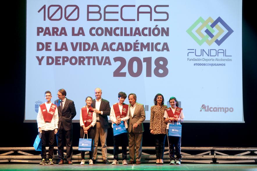 Entrega Becas FUNDAL 2018 - Imagen en el escenario de las autoridades presentes en el acto, entre ellas el alcalde García de Vinuesa y varios alumnos en el momento de recibir su beca.