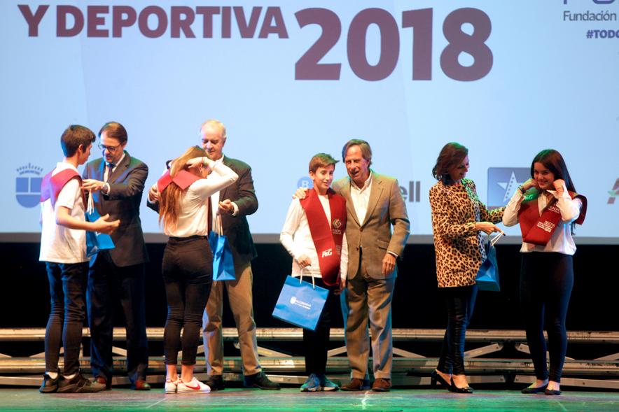 Entrega Becas FUNDAL 2018 - Imagen en el escenario de las autoridades presentes en el acto, entre ellas el alcalde García de Vinuesa y varios alumnos en el momento de recibir su beca.