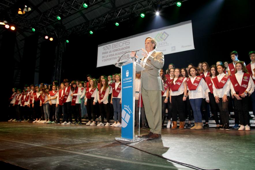 Entrega Becas FUNDAL 2018 - Imagen del alcalde García de Vinuesa en el escenario dirigiéndose al público asistente al acto y al fondo todos los alumnos becados.