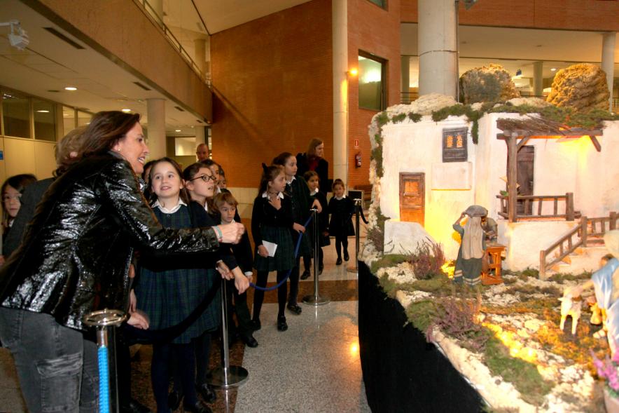 Inauguración Belén Municipal 2018 - Imagen lateral del Belén municipal y un grupo de niños viéndolo junto a Paloma Cano, la concejal.