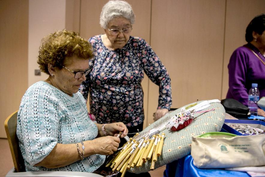 Participante bordando con bolillos. 2019