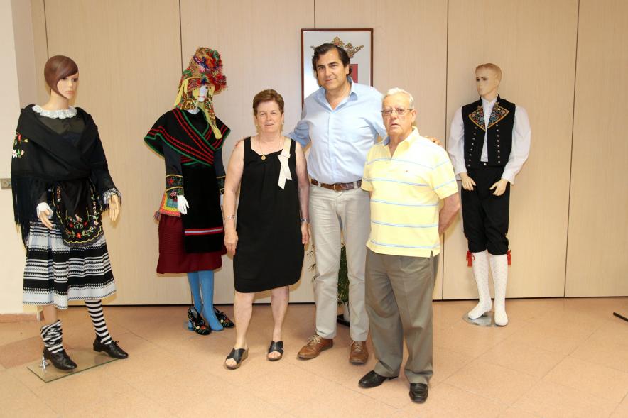 Inauguración Exposición de Bordados Casa de Extremadura - El concejal  junto a los trajes  y los artesanos.