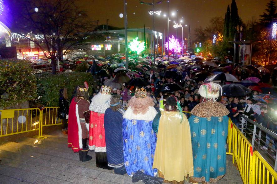 Cabalgata de Reyes 2018 - Imagen de los Reyes Magos de espalda con sus pajes saludando a la gente.