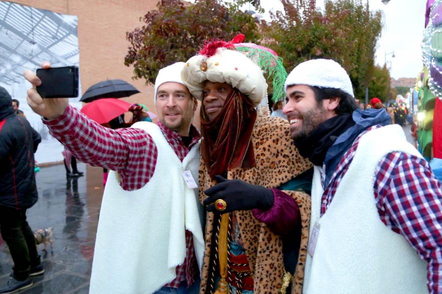 Cabalgata de Reyes 2018 - Imagen del Rey Baltasar haciéndose una foto con unas personas disfrazadas de pastores. 