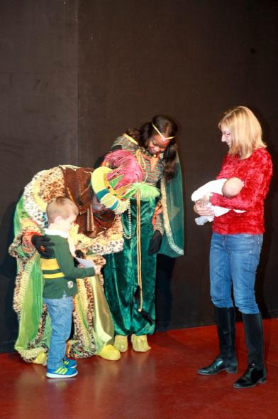 Cabalgata de Reyes 2017 - Imagen el Rey Baltasar y su paje en el escenario y unos niños.