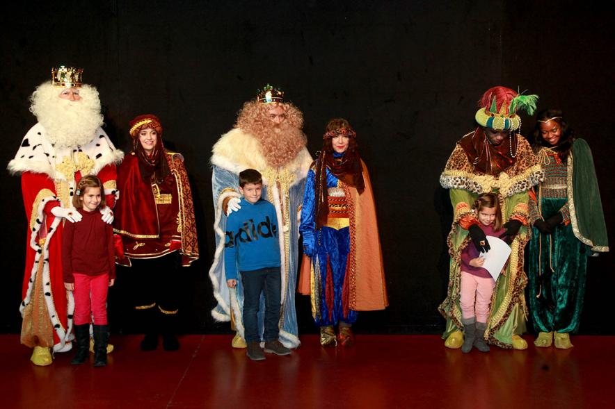 Cabalgata de Reyes 2017 - Imagen de los Reyes Magos y sus pajes en el escenario y unos niños.