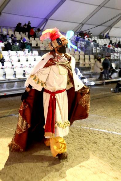 Cabalgata de Reyes 2021 - Primer plano del Rey Gaspar, con mascarilla,  a  pie, saludando.