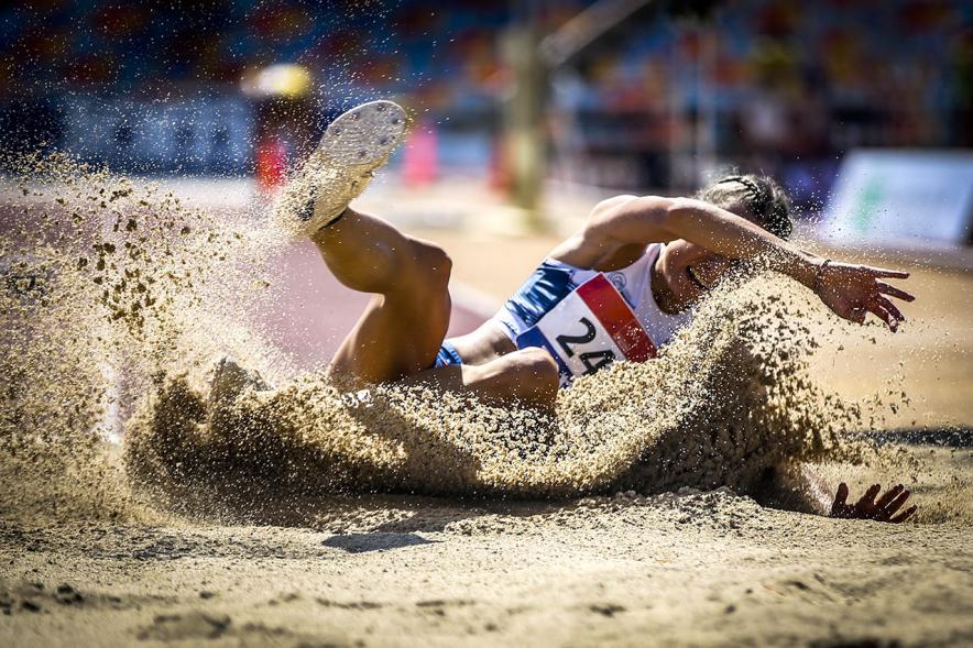 Campeonato de España de Atletismo - Salto de Altura y Triple Salto - Imagen de una atleta realizando un triple salto en el momento de caer en la arena.