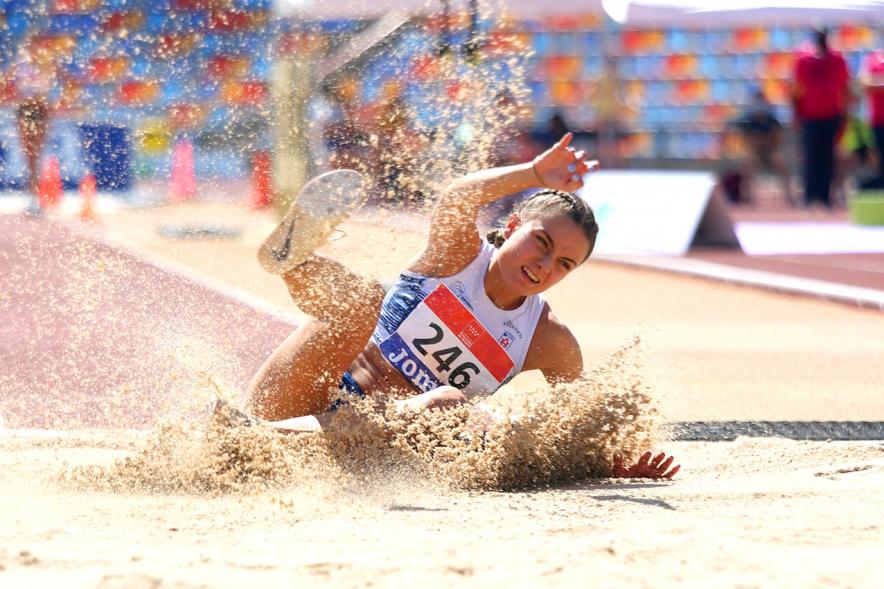 Campeonato de España de Atletismo - Salto de Altura y Triple Salto - IImagen de una atleta realizando un triple salto en el momento de caer en la arena.