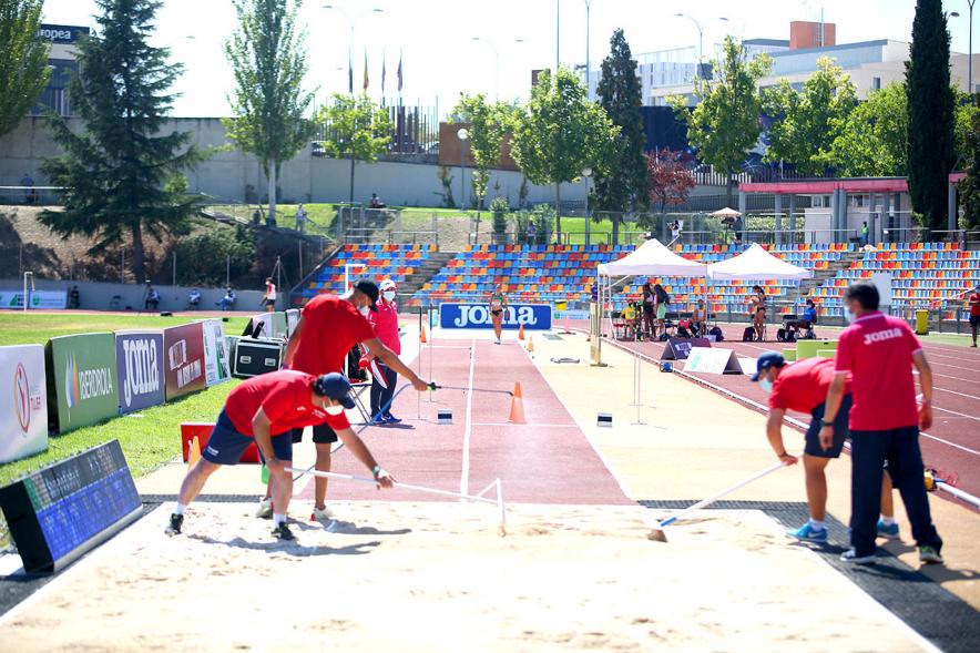 Campeonato de España de Atletismo - Salto de Altura y Triple Salto - Imagen de operarios alisando el foso de arena donde saltan las atletas.