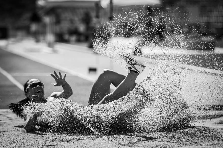 Campeonato de España de Atletismo - Salto de Altura y Triple Salto - Imagen en blanco y negro de una atleta realizando un triple salto en el momento de caer en la arena.