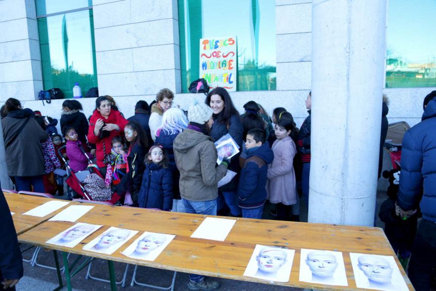 Desfile de Carnaval 2018 - Imagen de personas en la puerta del ayuntamiento en unas mesas largas maquillándose.