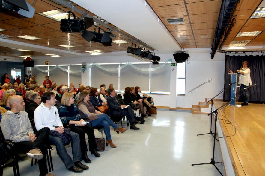 Entrega de Carnets a Mayores 2018 - Imagen lateral de parte de los asistentes y la concejal de Bienestar Social en el atril