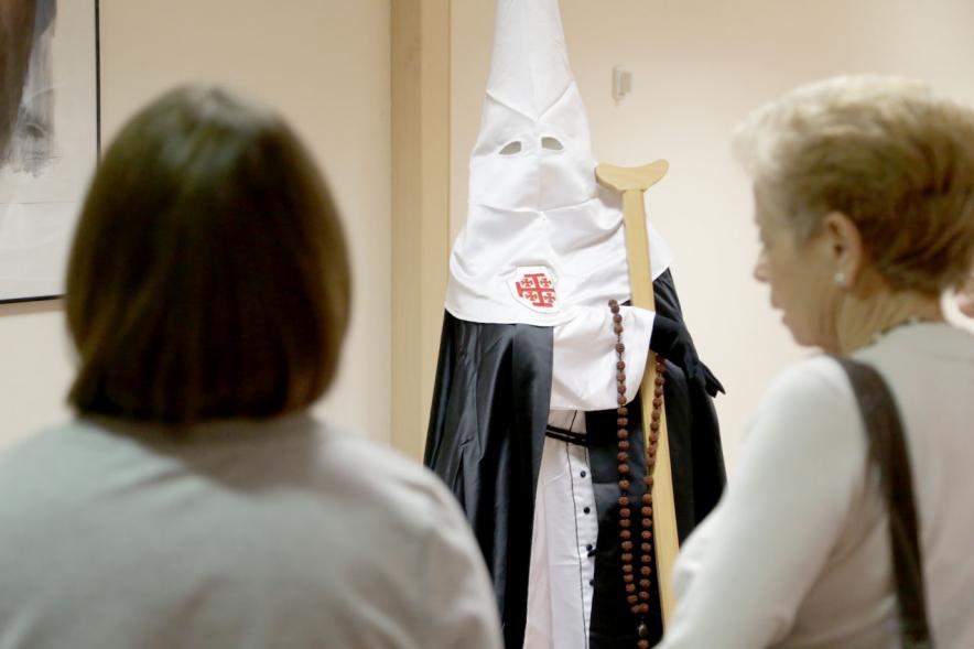 Inauguración de la Semana Santa Murciana - Imagen de dos visitantes junto al traje de Nazareno.