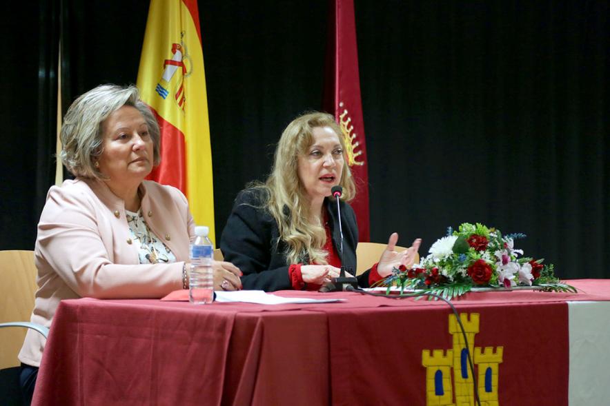 Inauguración Semana Cultural de Castilla La Mancha - Imagen de dos mujeres en la mesa presidencial y una de ellas dirigiéndose al público.