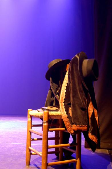 Festival Floklórico del Día de Castilla y León - Imagen de una silla en el escenario con ropa del grupo floklórico.