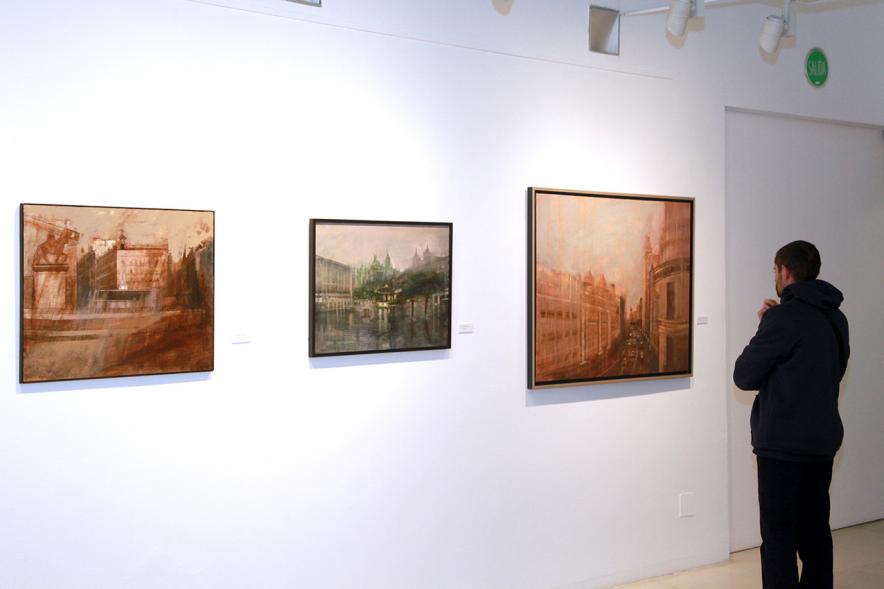 Inauguración Exposición de Charo Vaquerizo "Visiones Urbanas" - Imagen de persona mirando los cuadros de la exposición.
