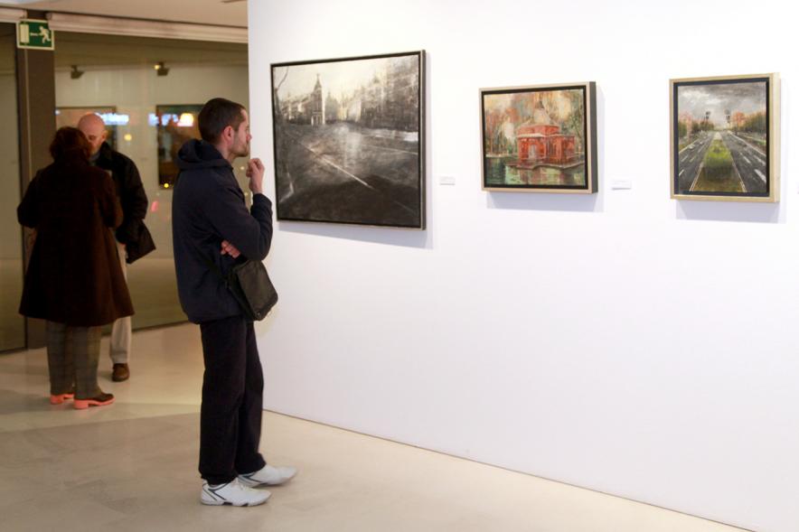 Inauguración Exposición de Charo Vaquerizo "Visiones Urbanas" - Imagen de persona mirando los cuadros de la exposición.