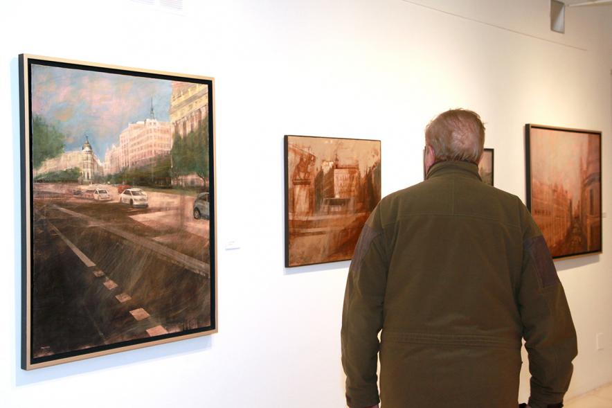 Inauguración Exposición de Charo Vaquerizo "Visiones Urbanas" - Imagen de persona mirando los cuadros de la exposición.