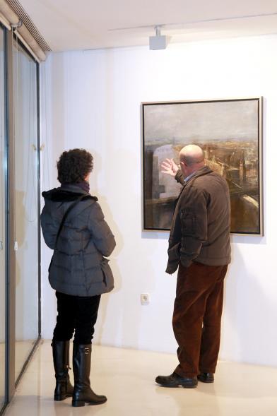 Inauguración Exposición de Charo Vaquerizo "Visiones Urbanas" - Imagen de persona mirando los cuadros de la exposición.