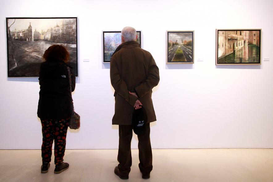 Inauguración Exposición de Charo Vaquerizo "Visiones Urbanas" - Imagen de personas mirando los cuadros de la exposición.