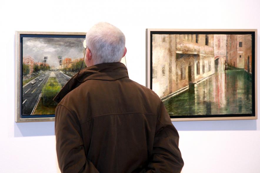 Inauguración Exposición de Charo Vaquerizo "Visiones Urbanas" - Imagen de persona mirando los cuadros de la exposición.