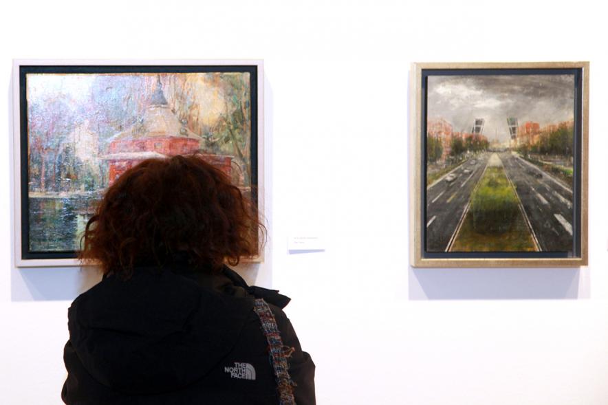 Inauguración Exposición de Charo Vaquerizo "Visiones Urbanas" - Imagen de persona mirando los cuadros de la exposición.
