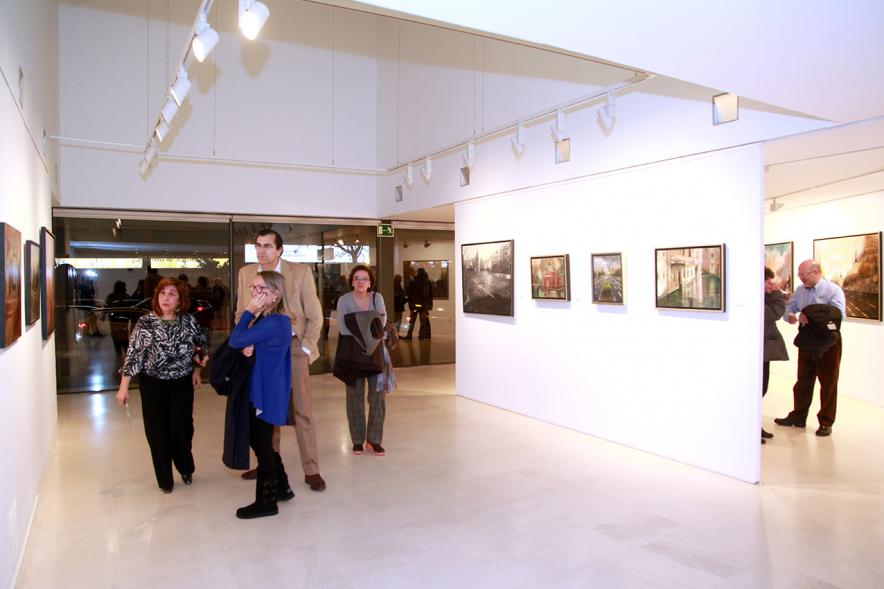 Inauguración Exposición de Charo Vaquerizo "Visiones Urbanas" - Imagen de personas mirando los cuadros de la exposición.