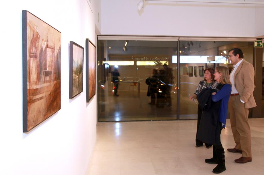 Inauguración Exposición de Charo Vaquerizo "Visiones Urbanas" - Imagen de personas mirando los cuadros de la exposición.