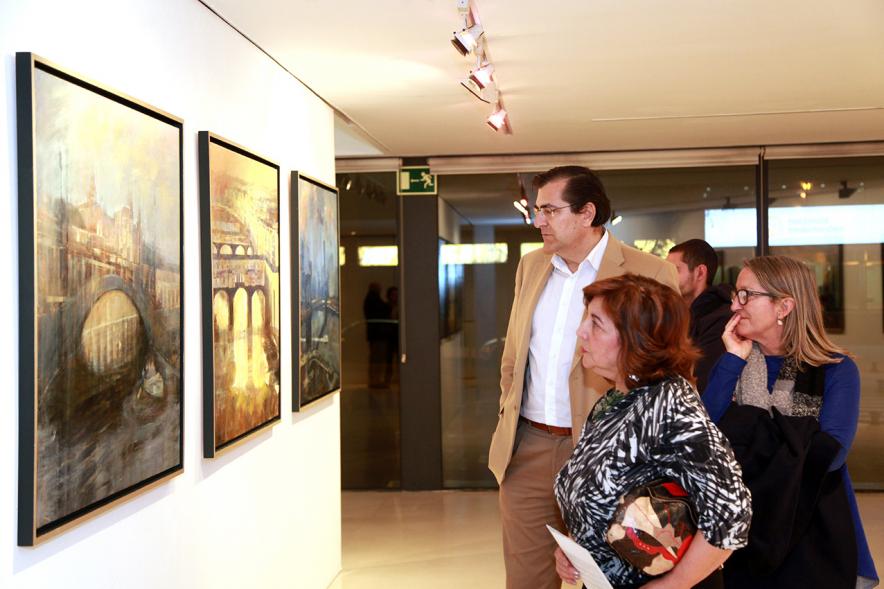 Inauguración Exposición de Charo Vaquerizo "Visiones Urbanas" - Imagen de personas mirando los cuadros de la exposición.