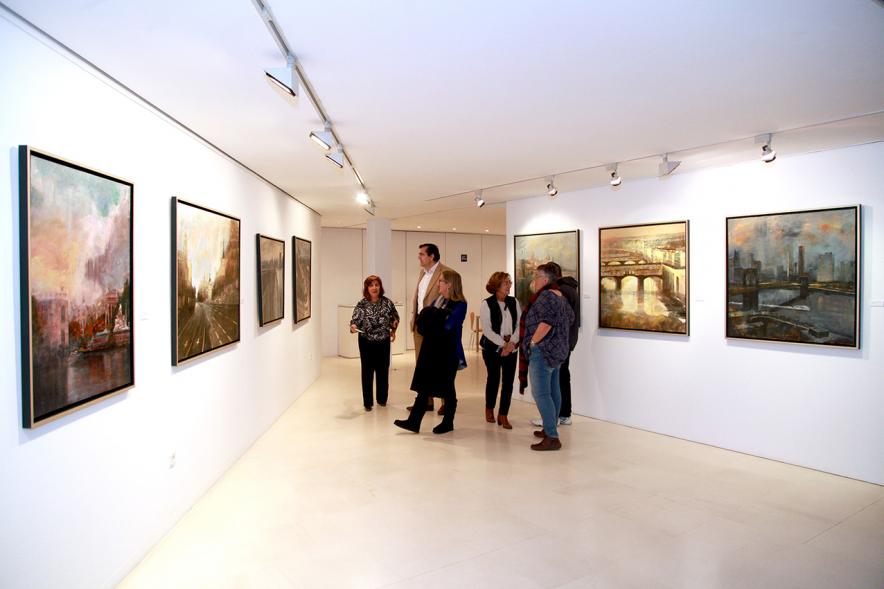 Inauguración Exposición de Charo Vaquerizo "Visiones Urbanas" - Imagen de persona mirando los cuadros de la exposición.