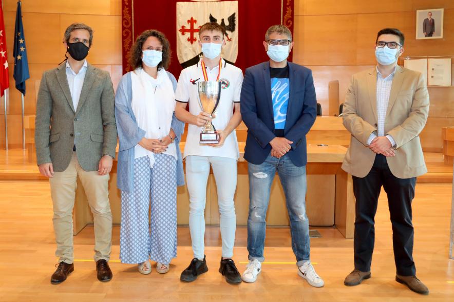  Recepción del Club Patín Alcobendas - Imagen de las autoridades posando  con el capitán del combinado juvenil que sujeta en sus manos la copa de campeón de España.