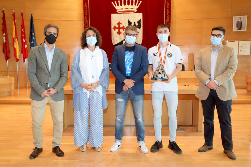  Recepción del Club Patín Alcobendas - Imagen de las autoridades posando  con el capitán del combinado juvenil que sujeta en sus manos la copa de campeón de España.