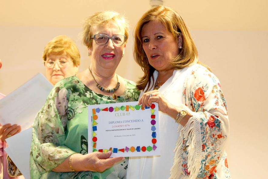 Representante del consistorio haciendo entrega del diploma a una galardonada. 