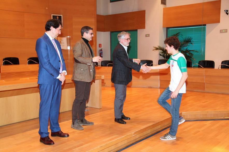 Recepción del Equipo de Natación - Imagen del saludo del alcalde Sánchez Acera junto a  las personalidades de la Federación  Madrileña de natación a un nadador. 