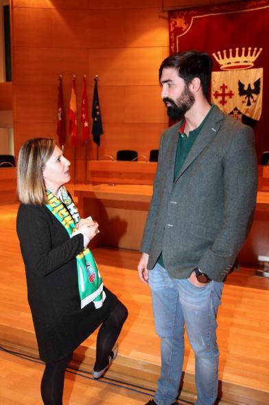 Recepción del Equipo de Natación - Imagen de la concejal de deportes María Espín, chalando con el entrenador del equipo.