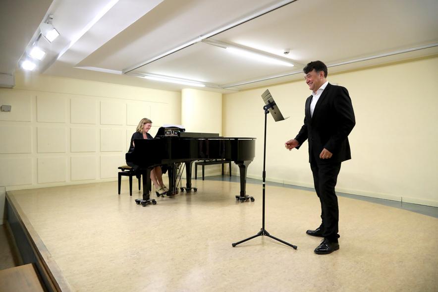 Homenaje a Debussy - Escuela de Música - Imagen en primer plano de un cantante y en segundo plano vemos a la pianista que le acompaña.
