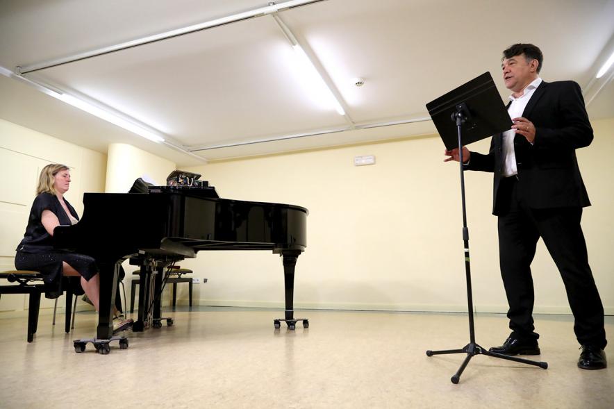 Homenaje a Debussy - Escuela de Música - Imagen en primer plano de un cantante y en segundo plano vemos a la pianista que le acompaña.