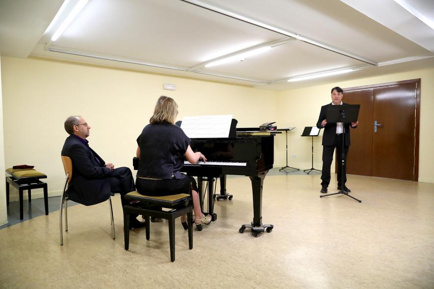 Homenaje a Debussy - Escuela de Música - Imagen escenario de la escuela de música, donde podemos ver a una pianista y a un cantante.