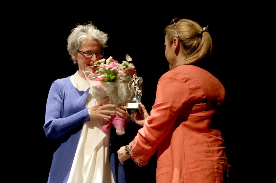 Presentadora entregando ramo de flores a la pianista. 