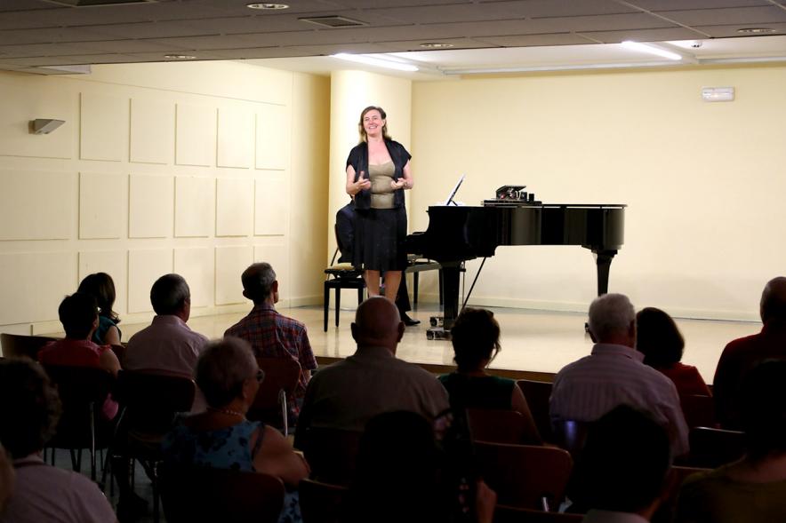 Homenaje a Debussy - Escuela de Música - Imagen lejana de una cantante en el escenario en un momento de su actuación.