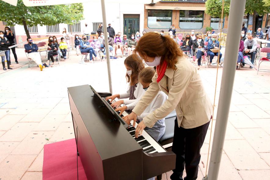 Concierto Infantil Escuela de Música en Distrito Centro - Primer plano de los niños tocando el piano con su profesora.