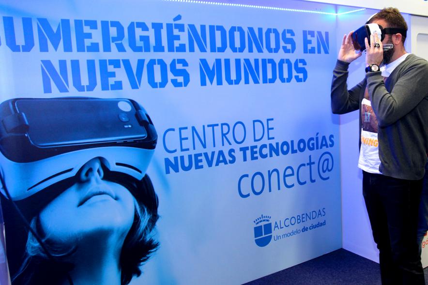 Visita Espacio Realidad Virtual en Conect@ - Un visitante junto al cartel promocional.