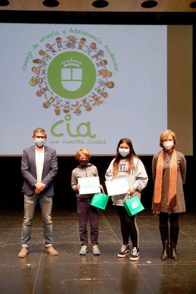 Nuevo Consejo de la Infancia y Adolescencia -  Imagen del alcalde Sánchez Acera, Ofelia Culebradas, responsable de juventud, con dos jóvenes premiados.