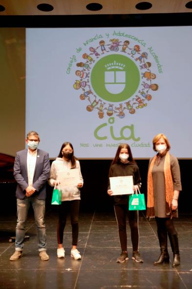 Nuevo Consejo de la Infancia y Adolescencia -  Imagen del alcalde Sánchez Acera, Ofelia Culebradas, responsable de juventud, con dos jóvenes premiados.