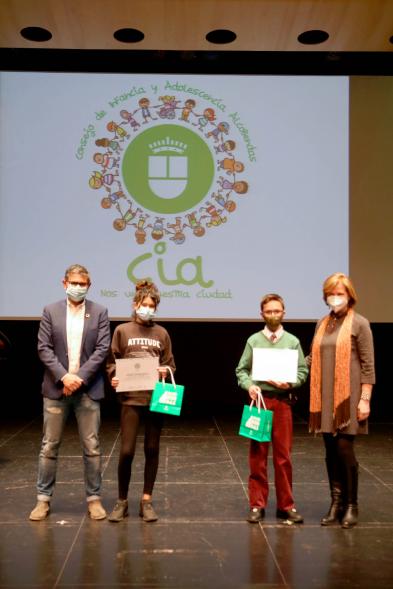 Nuevo Consejo de la Infancia y Adolescencia -  Imagen del alcalde Sánchez Acera, Ofelia Culebradas, responsable de juventud, con dos jóvenes premiados.