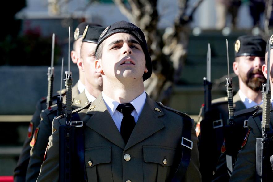 Detalle plano cercano de militares en firmes mientras se iza la bandera
